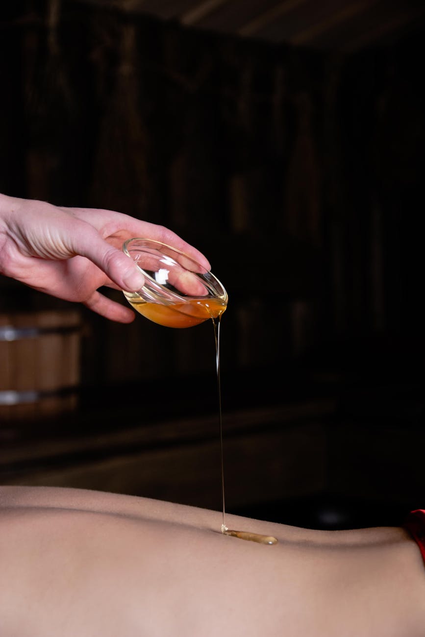 hand pouring oil on skin