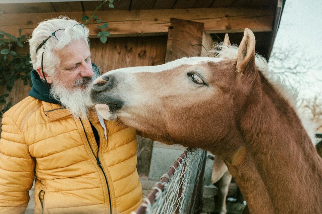 man interacting with horse on a winter day