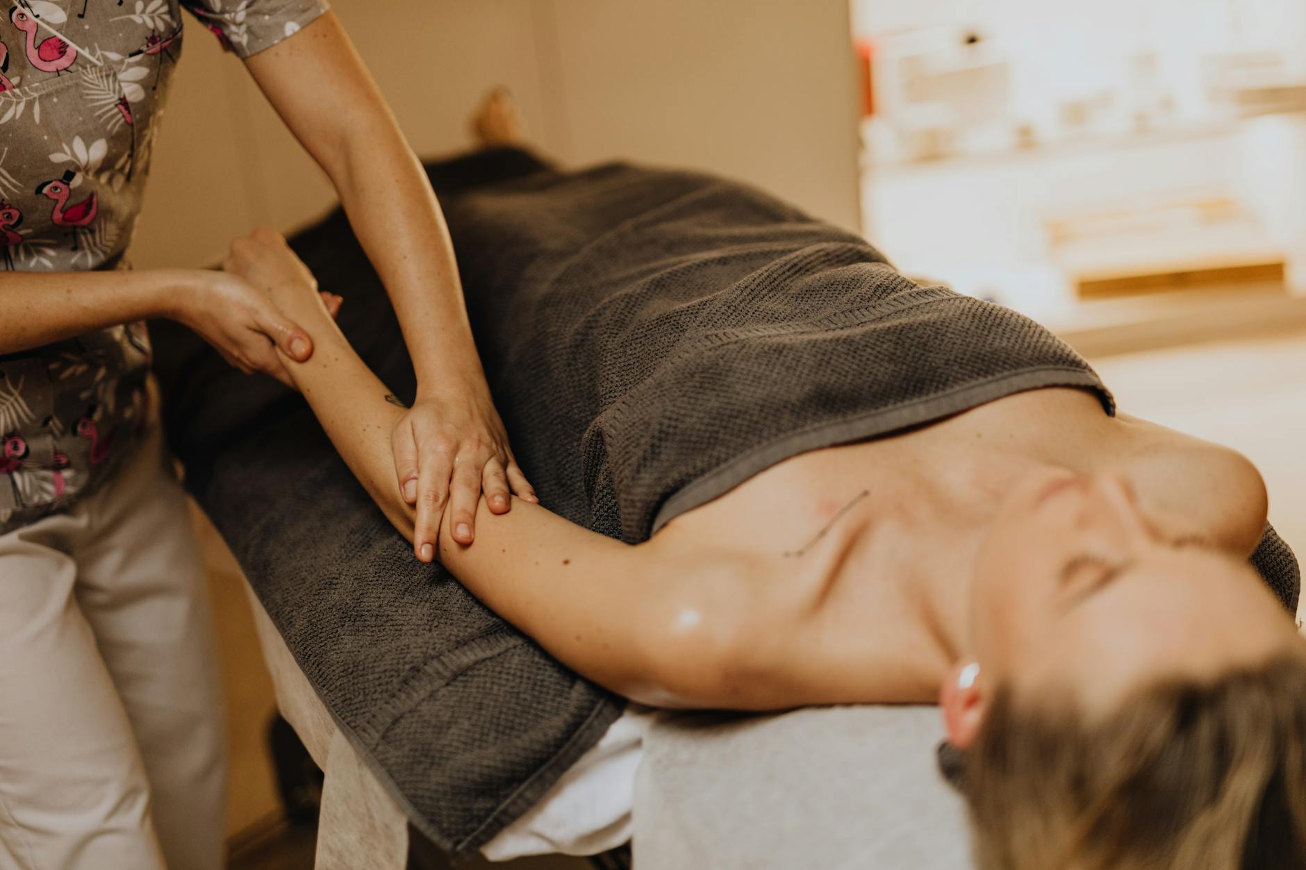 a masseuse massaging a woman s arm